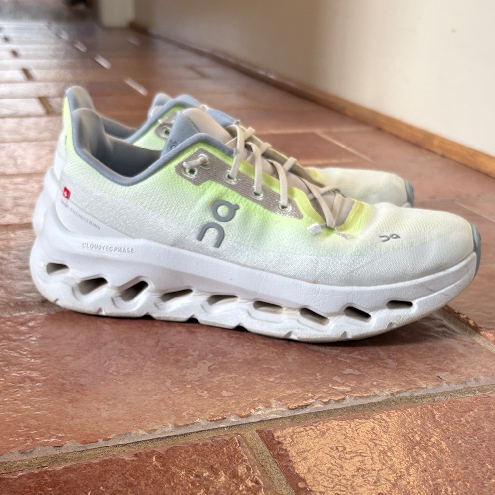 On cloud Running White and Cream Athletic Shoes with a neon finish.